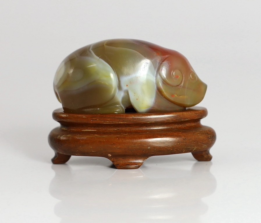 A Chinese banded agate figure of a recumbent pig, 18th/19th century, 5.4cm long, wood stand